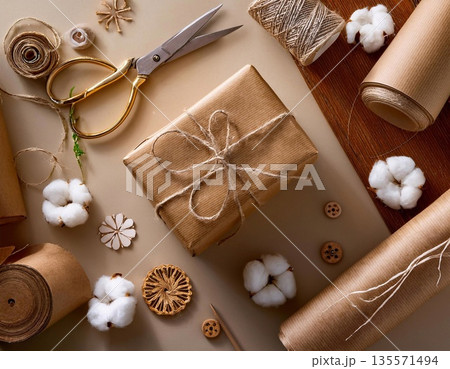 A beautifully wrapped gift with brown paper and cotton balls around it on the table 135571494