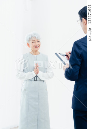 営業マンの説明を聞くシニア女性 営業マンの説明を聞くシニア女性 135571691