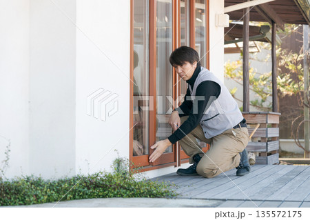 窓の修理をする作業服の男性 135572175
