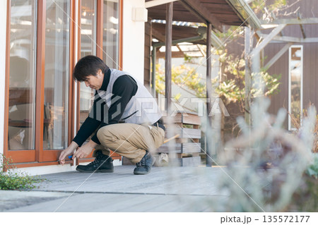 窓の修理をする作業服の男性 窓の修理をする作業服の男性 135572177