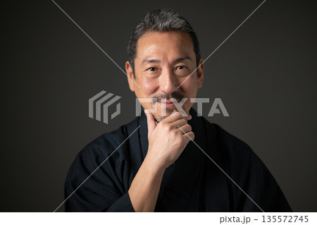 黒背景の微笑む男性 135572745