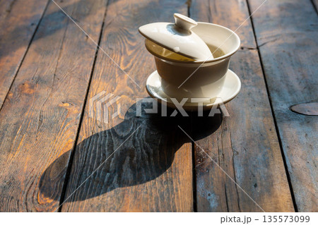 Tea pot sits on wooden table in Chengdu Sichuan during afternoon light 135573099