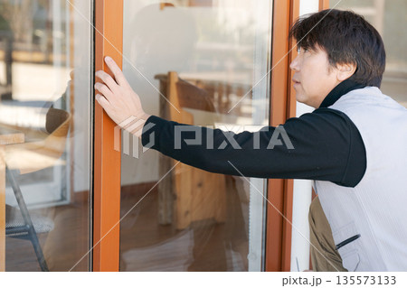 窓の修理をする作業服の男性 135573133