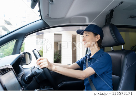 車で荷物を配達するミドルの女性配達員 135573171