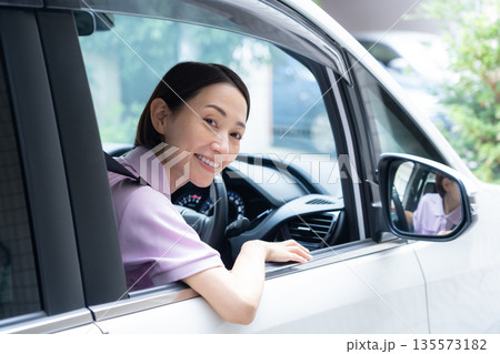 車で訪問介護をするミドルの女性介護士 135573182