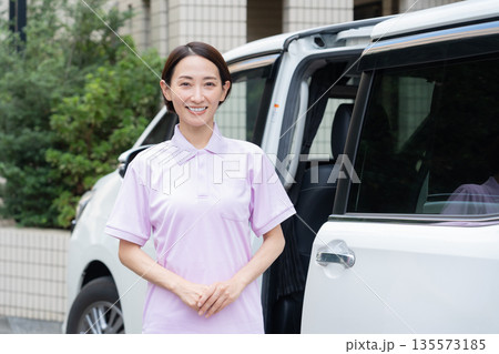 車で訪問介護をするミドルの女性介護士 135573185