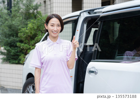車で訪問介護をするミドルの女性介護士 135573188