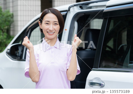 車で訪問介護をするミドルの女性介護士 135573189