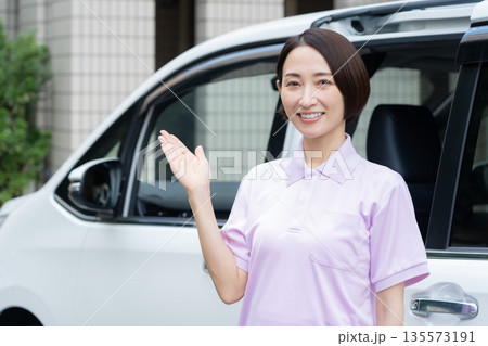 車で訪問介護をするミドルの女性介護士 135573191