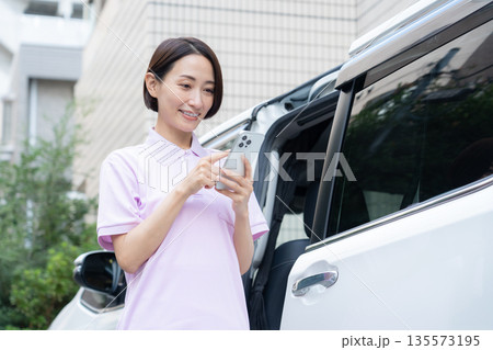 車で訪問介護をするミドルの女性介護士 車で訪問介護をするミドルの女性介護士 135573195