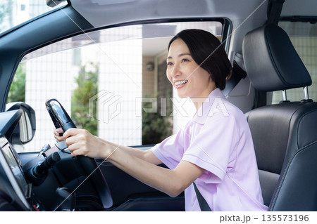 車で訪問介護をするミドルの女性介護士 車で訪問介護をするミドルの女性介護士 135573196