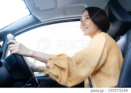 車でドライブをするミドルの女性 135573249