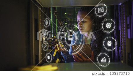 Managing network cables, technician examining connections in data center, with overlays, copy space 135573710