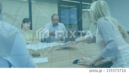 Discussing team in business attire analyzing financial data at table in meeting room with documents Discussing team in business attire analyzing financial data at table in meeting room with documents 135573718