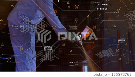 Spraying barrel by painter wearing coverall, gloves in workshop with spray gun and digital graphics Spraying barrel by painter wearing coverall, gloves in workshop with spray gun and digital graphics 135573765