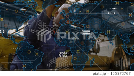 Adjusting machinist wearing blue shirt operating milling machine in shop, with digital map overlay 135573767