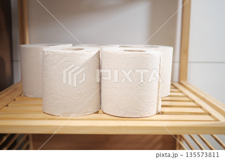 Paper rolls stored on a wooden shelf in a room 135573811
