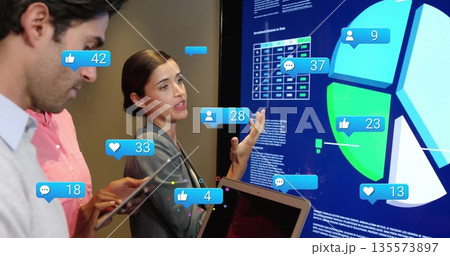Gesturing team member in blazer presenting data on touchscreen at meeting, tablet reaction icons Gesturing team member in blazer presenting data on touchscreen at meeting, tablet reaction icons 135573897