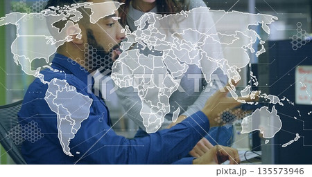 Pointing woman guiding blue-shirted man analyzing data on computer in office with world map overlay Pointing woman guiding blue-shirted man analyzing data on computer in office with world map overlay 135573946