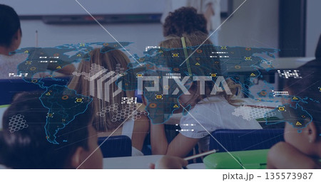 Teaching teacher guiding student writing at desks by whiteboard with yellow headphones, map overlay 135573987