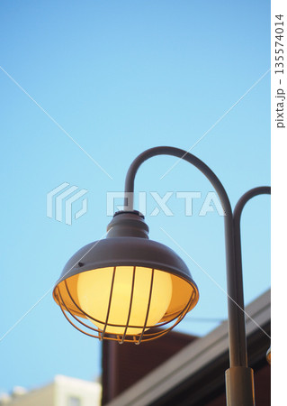 Street lamp shines bright in clear sky at sunset Street lamp shines bright in clear sky at sunset 135574014