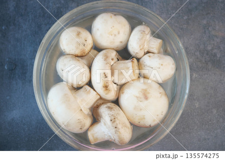 Fresh white mushrooms soaking in water for meal preparation Fresh white mushrooms soaking in water for meal preparation 135574275