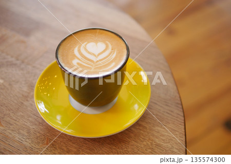 Coffee served in a stylish cup on a wooden table Coffee served in a stylish cup on a wooden table 135574300