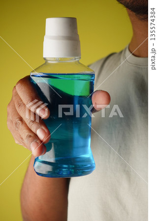 hand holding a mouth wash liquid container hand holding a mouth wash liquid container 135574384