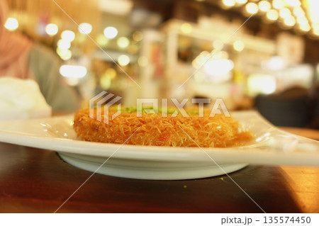 Delicious turkish kunefe dessert on a table Delicious turkish kunefe dessert on a table 135574450
