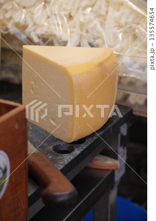 Cheese block on cutting board in kitchen setting 135574654