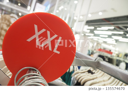 Clothing rack sign showing XXL size in a retail store 135574670