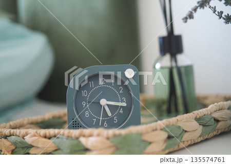 Modern clock on a tray near aromatic diffuser on a table Modern clock on a tray near aromatic diffuser on a table 135574761