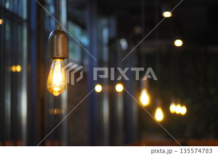 Hanging lights illuminate indoor space in evening setting 135574783