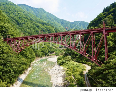 新緑の渓谷に架かる赤い橋 135574787