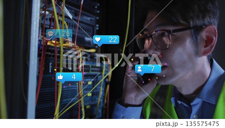 Calling vest-wearing tech using smartphone in server room, with rack cables and icons, copy space Calling vest-wearing tech using smartphone in server room, with rack cables and icons, copy space 135575475