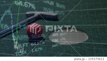 Resting silver putter behind red golf ball near rimmed hole on felt mat, with stock overlay Resting silver putter behind red golf ball near rimmed hole on felt mat, with stock overlay 135575611