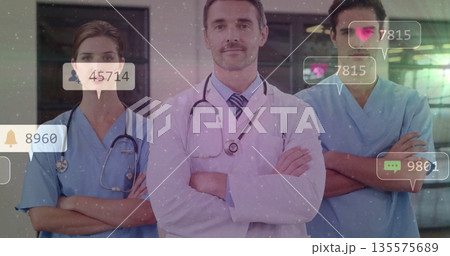 Standing medical team folding arms in clinical hallway, with stethoscopes notification icons Standing medical team folding arms in clinical hallway, with stethoscopes notification icons 135575689
