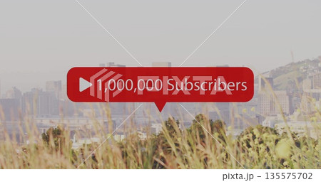 Hovering red subscriber graphic showing 1,000,000 Subscribers above meadow with hazy skyline 135575702