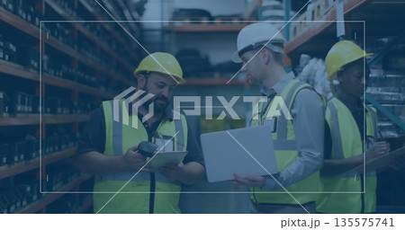 Workers in vests and helmets scanning inventory using scanner, checking on tablet in storage aisle Workers in vests and helmets scanning inventory using scanner, checking on tablet in storage aisle 135575741