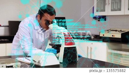 Peering scientist in lab coat examining sample through microscope in lab, with digital overlay 135575882
