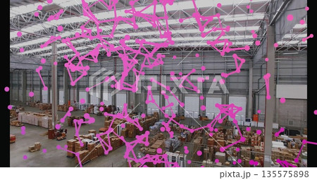 Showing warehouse interior storing wooden pallets and metal racks, with magenta dot network overlay 135575898