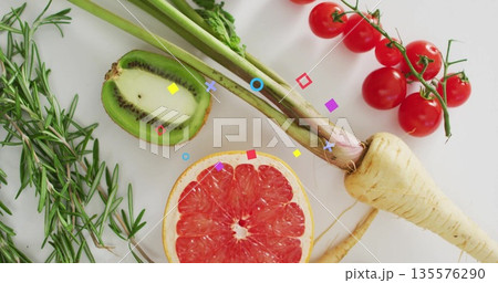 Arranging halved grapefruit and kiwi, tomatoes, parsnip, rosemary on kitchen counter, overlays Arranging halved grapefruit and kiwi, tomatoes, parsnip, rosemary on kitchen counter, overlays 135576290