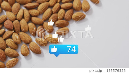 Cluster of almonds on white tabletop, showing thumbs-up icons and notification bubble, copy space Cluster of almonds on white tabletop, showing thumbs-up icons and notification bubble, copy space 135576323