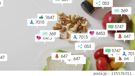 Flat lay showing healthy food items, amber bottle on counter, with social media notification icons Flat lay showing healthy food items, amber bottle on counter, with social media notification icons 135576351