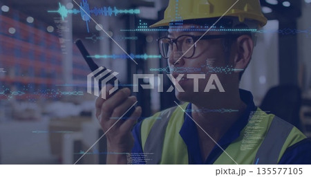 Speaking Korean warehouse worker holding walkie-talkie in warehouse, with tech overlays, copy space 135577105
