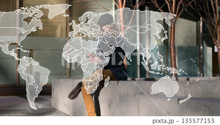 Sitting adult male checking smartphone on bench in plaza, wearing dark coat with world map overlay Sitting adult male checking smartphone on bench in plaza, wearing dark coat with world map overlay 135577153