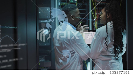 Network engineers in lab coats discussing and analyzing 3D data overlays in data center with racks 135577191