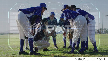 Gathering baseball players huddling on outfield grass in uniforms, with bat, gloves, catcher's gear 135577221