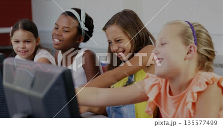 Pointing and smiling four female students using computers in school lab, with keyboards and mice Pointing and smiling four female students using computers in school lab, with keyboards and mice 135577499
