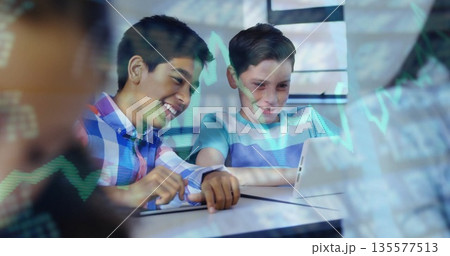 Two classmates pointing stylus at tablet and studying coding in study room, with graph overlay 135577513